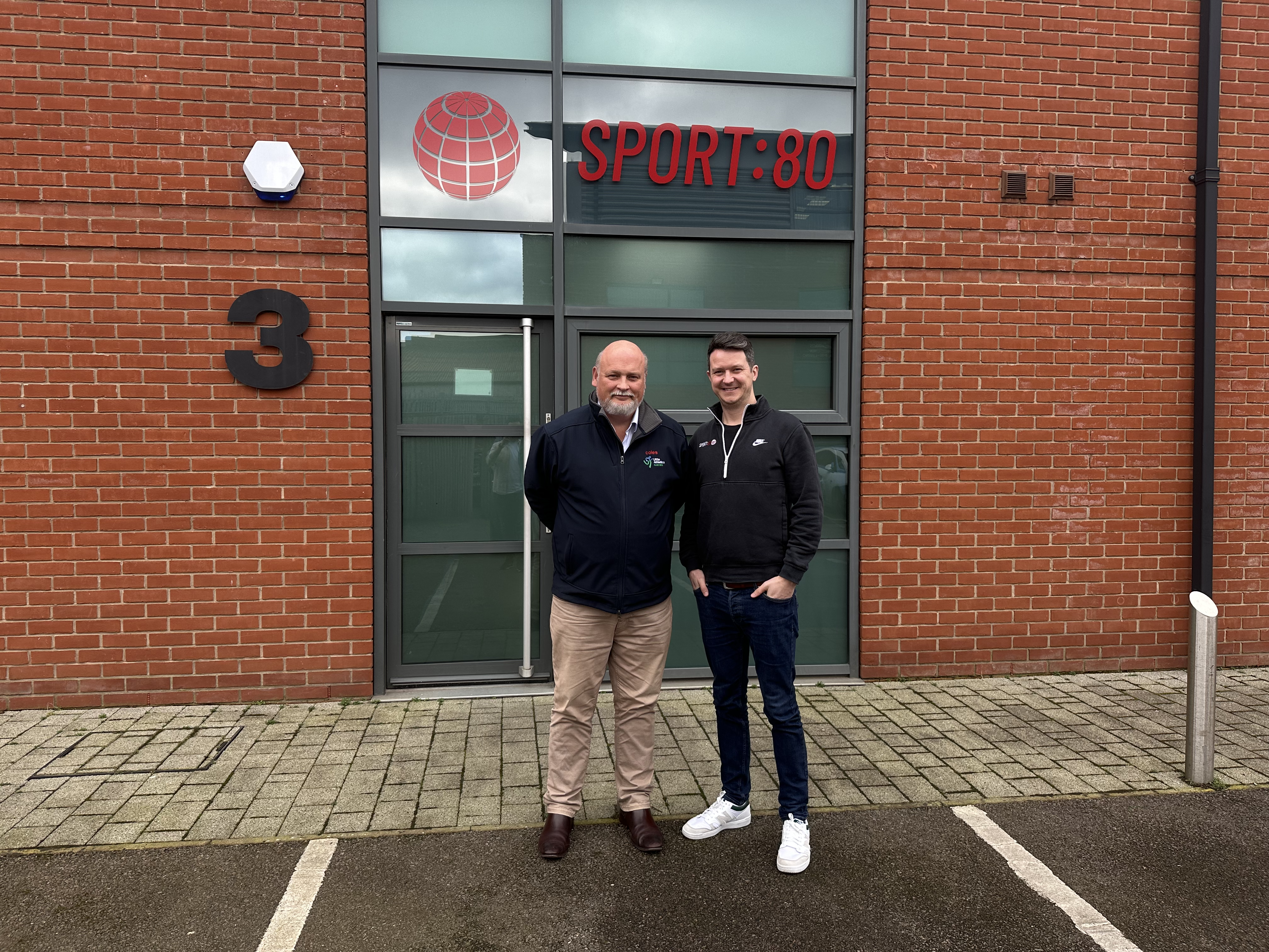 Myles Foreman, CEO of Little Athletics Australia, stood alongside Jonny Turner, COO of Sport:80, smiling outside of Sport:80's headquarters